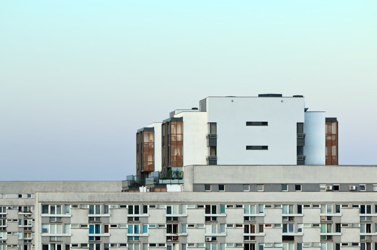 portfolio-05 Minimalist view of a modern apartment building at dawn with a clear sky.